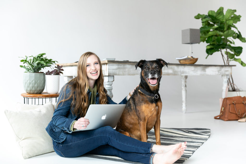 Dog and entrepreneur sit on the floor smiling