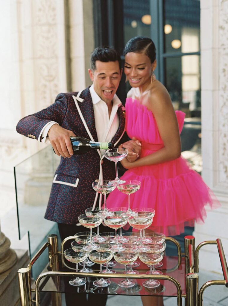 Couple pours into a champagne tower at a wedding